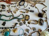 many different necklaces and bracelets laid out on a table