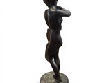 statue of a woman standing on a base with her hands behind her head