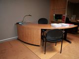 un bureau avec une chaise et une lampe dans un coin