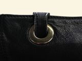 a close up of a black purse with a metal ring