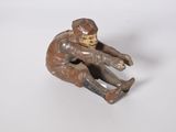 figurine représentant un garçon assis sur un skateboard posé sur une surface blanche