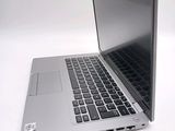 a silver laptop with a black keyboard on a white surface