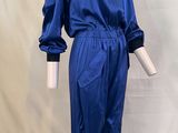 combinaison en satin bleu avec manches et poignets à fermeture éclair, présentée sur un mannequin