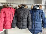 three jackets hanging on a rack in a room