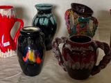 many different vases sitting on a table with a white background