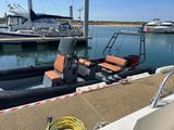 a boat that is parked at a dock with a boat in the background