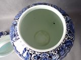 a blue and white vase with a lid sitting on a table