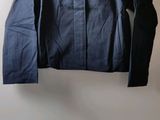 a blue jacket and a pair of black pants on a white table