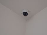 a camera mounted on the ceiling in the corner of a room