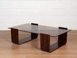 une photo d'une table basse avec un plateau en verre posée sur un parquet