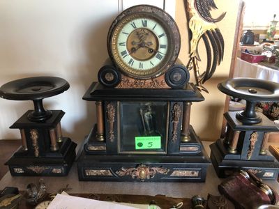 une horloge posée sur une table, à côté d'autres objets