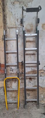 deux échelles appuyées contre le mur, l'une à côté de l'autre