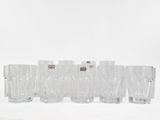 set of six clear glass tumbles in a line on a white surface