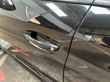 a close up of a car door handle with a sticker on it