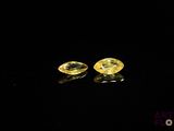 a pair of yellow sapphires on a black surface
