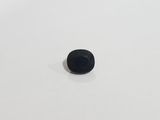 a small black stone sitting on top of a white surface