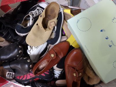 une pile de chaussures et un sac par terre