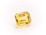 a yellow sapphire stone on a white background