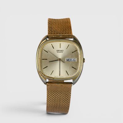 un gros plan d'une montre sur une surface blanche avec un fond blanc