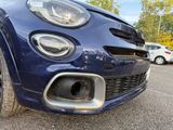 a close up of a blue car parked in a parking lot