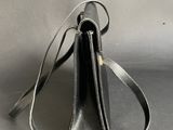 a close up of a black purse on a gray surface