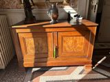 a wooden cabinet with a vase on top of it