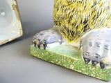 une statue représentant un lion assis sur une table, à côté d'un cadre photo