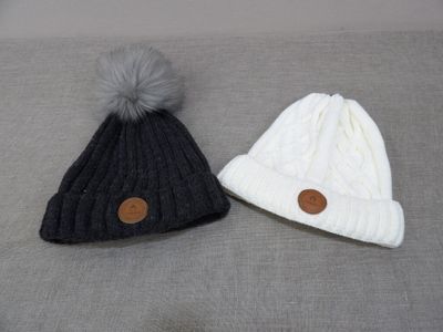 two hats with buttons on them are sitting on a bed