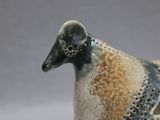 a ceramic bird that is sitting in a cup