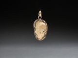 un pendentif en or et en argent représentant le visage d'une femme