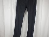 a pair of black pants hanging on a hanger in front of a white curtain