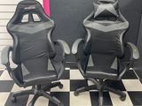 deux fauteuils de course noirs et gris posés sur un sol à carreaux