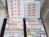 beaucoup de timbres posés sur une table, à côté d'un livre