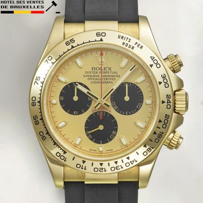 an image of a gold and black watch with a black rubber strap