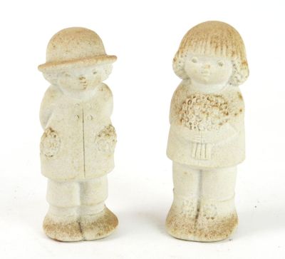 two ceramic figurines of a boy and a girl