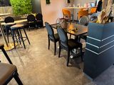 tables and chairs are lined up in a restaurant with a wall of greenery behind them