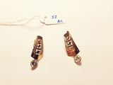two pieces of jewelry on a white surface with a price tag