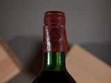 a bottle of wine sitting on a table with a wooden block in the background