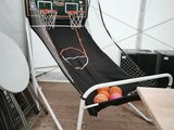 un hamac sur lequel sont posés un panier de basket et un ballon de basket