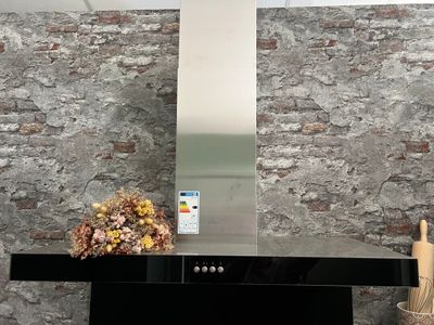 une photo d'une cuisine avec une cuisinière et un mur en briques