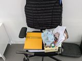 a black chair with books and a yellow box on it