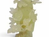 yellow jade carved vase with flowers and leaves on a stand