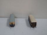 two toy trains sitting on a table next to each other