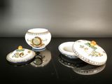 three pieces of porcelain sitting on a black table