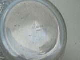 a close up of a glass vase with a silver lid
