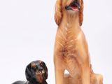 deux figurines représentant un chien et un autre chien, assis l'un à côté de l'autre