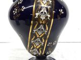 a blue vase with gold decoration on it on a stand