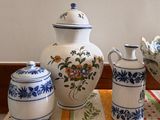 three vases and a bowl sitting on a table