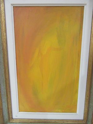yellow and orange painting in a gold frame on a green wall
