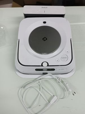 a white electronic device sitting on a table next to a cup